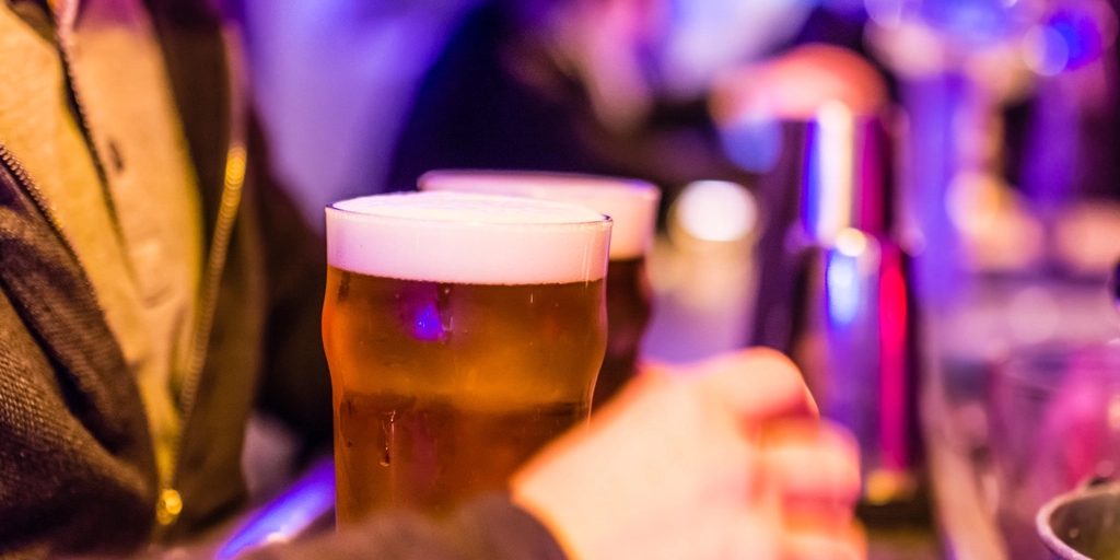 A pint of beer held up in a bar