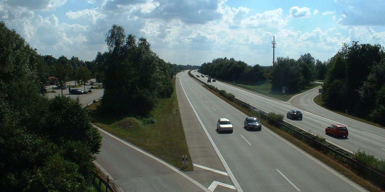 Cars on a German motorway between wooded banks