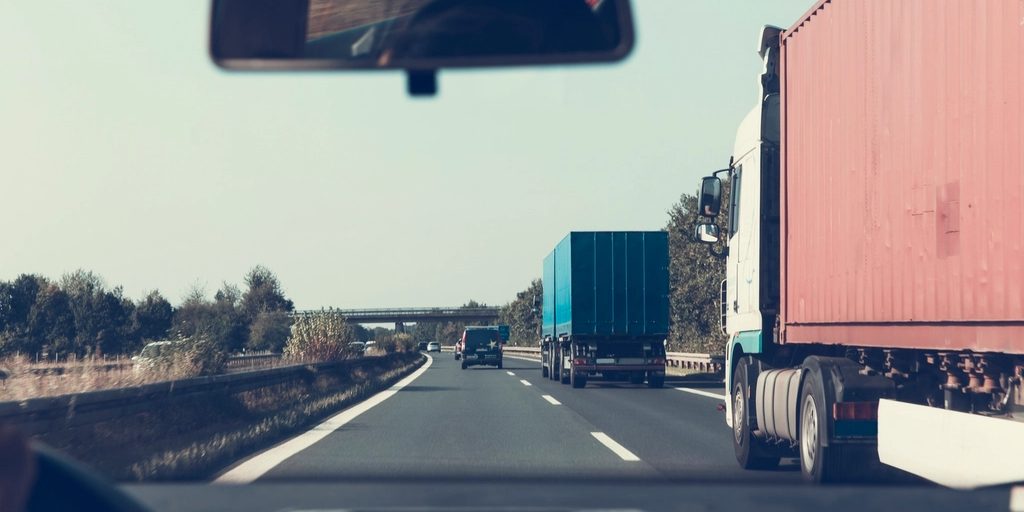 A motorway seen through a windscreen, following a lorry