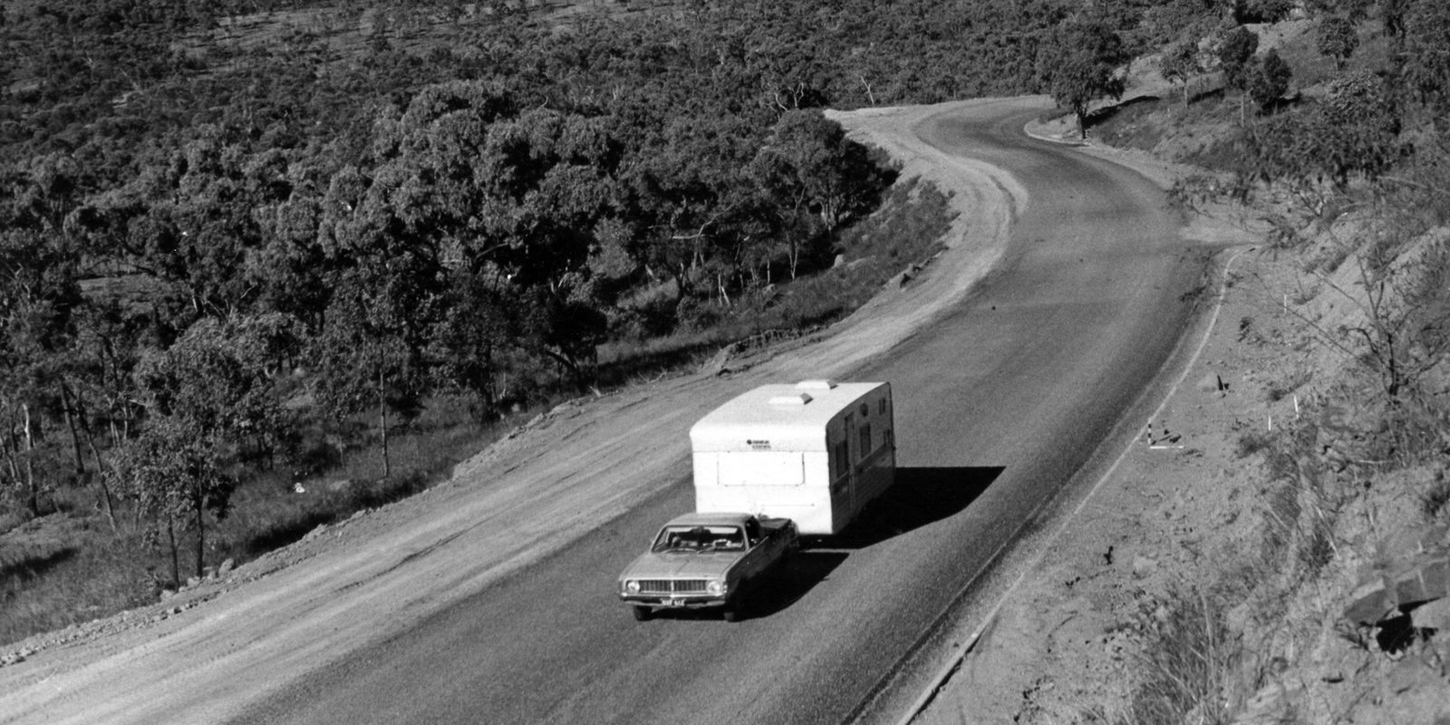 A car towing a caravan on a country road