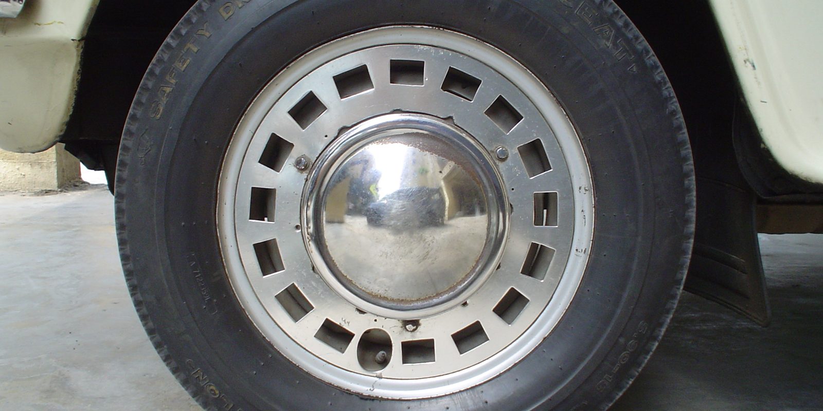 A steel wheel and tyre on a parked vehicle