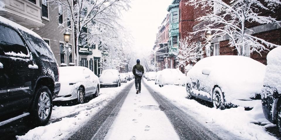 Snow-covered street with parked cars